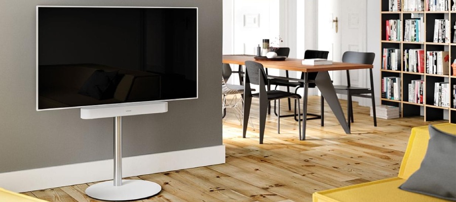 TV bianca su un supporto bianco con soundbar bianca in salotto.